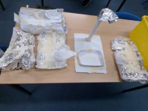 A photo of some makeshift rafts created by pupils out of kitchen foil and masking tape.