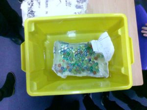 A photo of a raft created by a pupil sitting in a green plastic box on a desk.