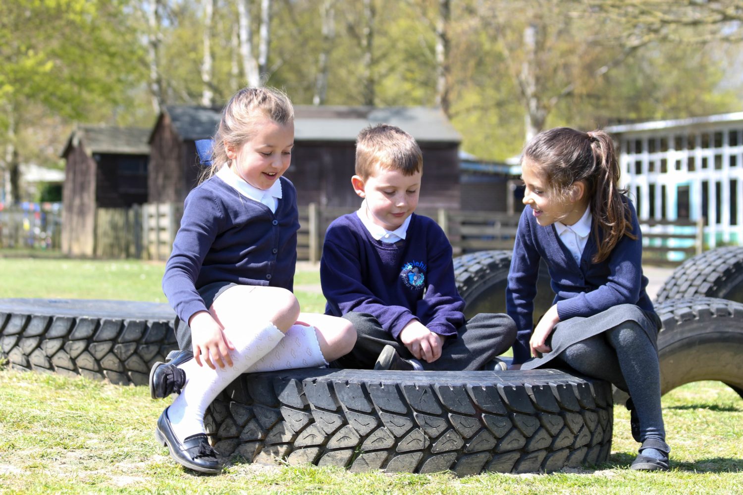 Three students sat on a tyre